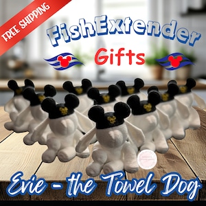May include: A group of white plush towel dogs with black ears and a gold embroidered Mickey Mouse icon on the forehead. The text FishExtender Gifts and Evie - the Towel Dog is displayed in blue and red font against a blurred kitchen background.