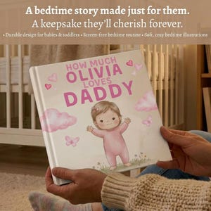 Peut inclure: Un livre pour enfants personnalis&eacute;, intitul&eacute; "How Much Olivia Loves Daddy". La couverture pr&eacute;sente une illustration d'un b&eacute;b&eacute; en rose, entour&eacute; de c&oelig;urs et de nuages. Le livre est ouvert, r&eacute;v&eacute;lant le titre.