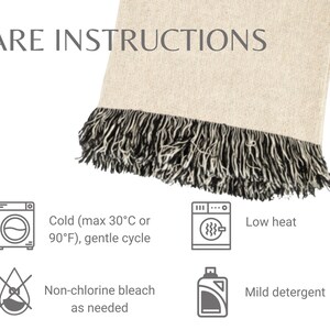 May include: A beige blanket with a black fringe, displaying care instructions. The text reads "CARE INSTRUCTIONS" and includes icons for cold wash (max 90&deg;F), low heat, non-chlorine bleach, and mild detergent.