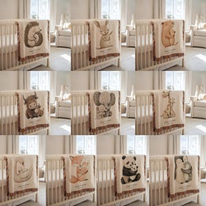 May include: A collection of baby blankets with various animal illustrations, including a hedgehog, rabbit, bear, yak, elephant, giraffe, swan, fox, panda, and penguin. Each blanket features a fringed edge and the text "LIAM + MOM" below the animal design.