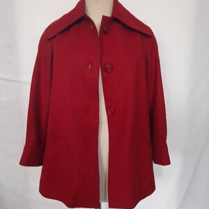 K&ouml;nnte beinhalten: Eine rote, kurz&auml;rmelige Jacke mit Kragen und vier Kn&ouml;pfen vorne.
