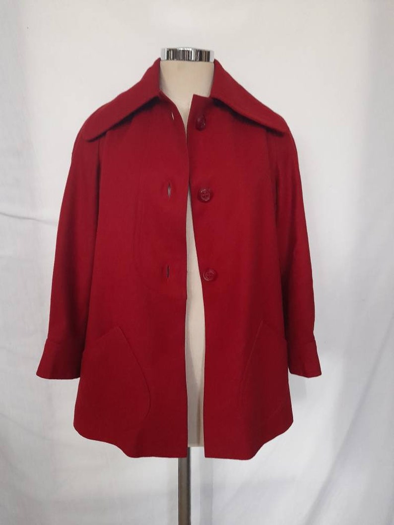 K&ouml;nnte beinhalten: Eine rote, kurz&auml;rmelige Jacke mit Kragen und vier Kn&ouml;pfen vorne.