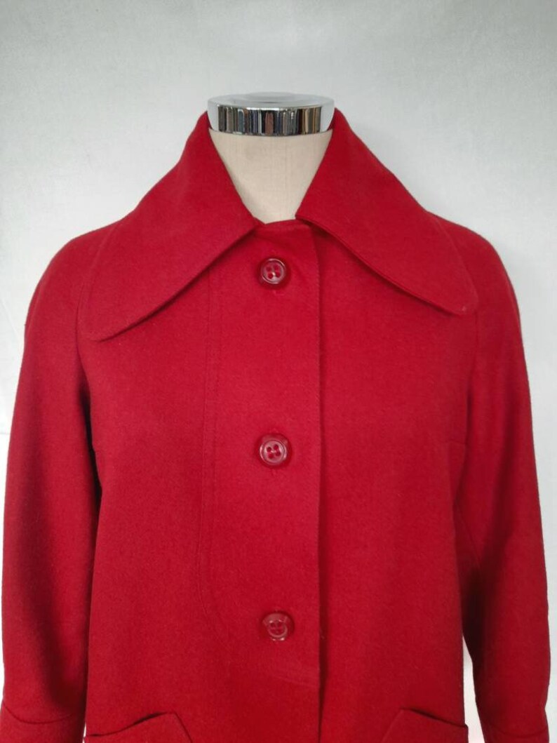 K&ouml;nnte beinhalten: Ein roter Wollmantel mit Kragen und f&uuml;nf Kn&ouml;pfen vorne.