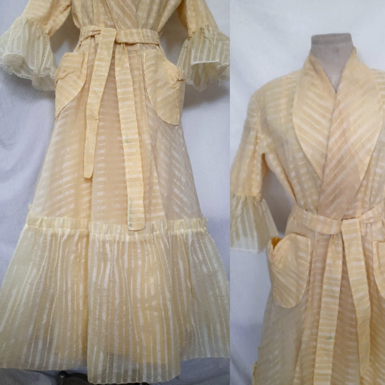 May include: A pale yellow sheer robe with a striped pattern, long sleeves with ruffled cuffs, and a matching sash tie. The robe has two patch pockets and a ruffled hem.