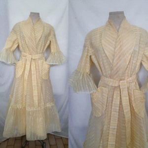 May include: A long, yellow, sheer robe with a striped pattern, ruffled sleeves, and a sash tie. The robe has two pockets and a ruffled hem.