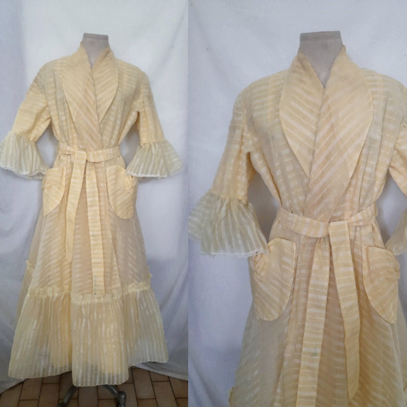 May include: A long, yellow, sheer robe with a striped pattern, ruffled sleeves, and a sash tie. The robe has two pockets and a ruffled hem.