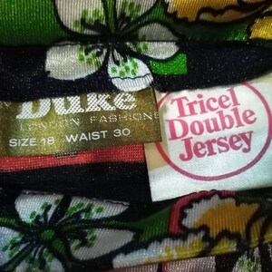 Pode incluir: Um tecido floral preto e branco com uma etiqueta dourada que diz "Duke London Fashions" e "Size 18 Waist 30". Uma etiqueta branca com letras cor-de-rosa diz "Tricol Double Jersey".