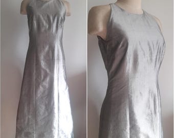 Vestido largo de cóctel plateado sin mangas, estilo vintage de los años 90, con escote redondo alto y brillo metálico.