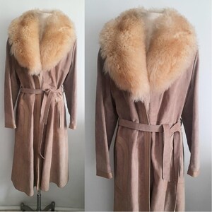 May include: A long, brown suede coat with a large, fluffy, light brown fur collar. The coat has a belt and a long, flowing silhouette.