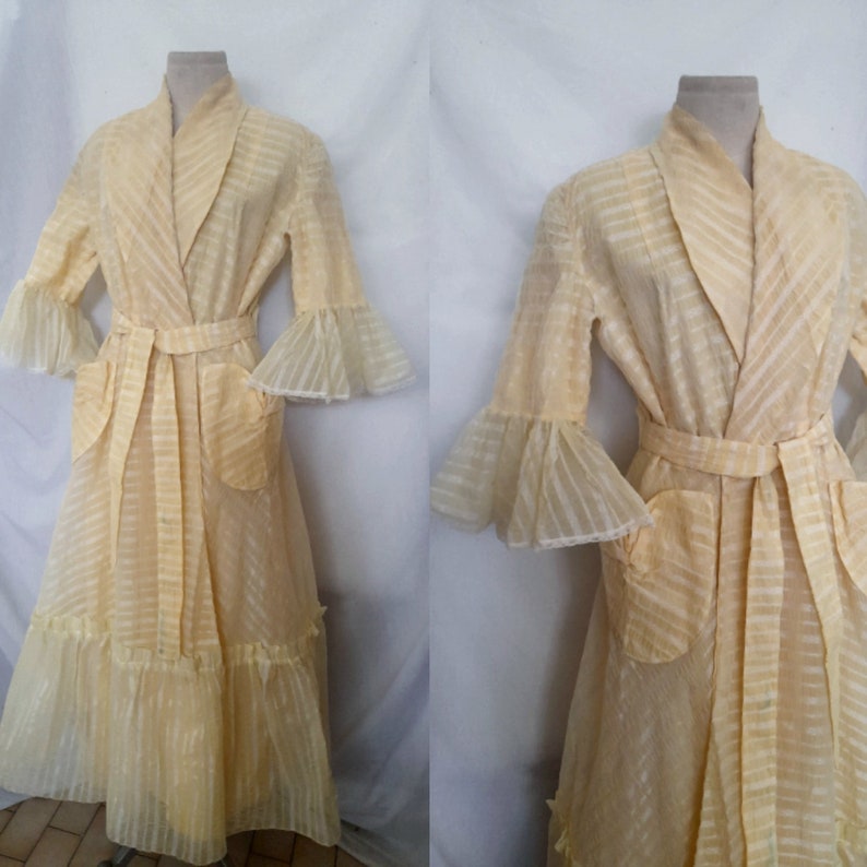 May include: A yellow sheer robe with a striped pattern and ruffled sleeves. The robe has a tie belt and two pockets.