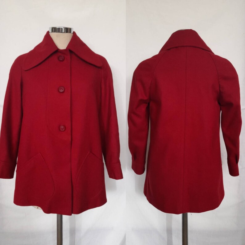 K&ouml;nnte beinhalten: Ein roter Wollmantel mit Kragen und vier Kn&ouml;pfen vorne. Der Mantel hat zwei Taschen vorne und lange &Auml;rmel.