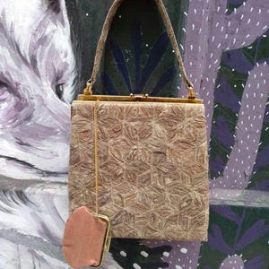 Può includere: Una borsa vintage marrone con chiusura e catena dorate. La borsa ha un design testurizzato e intrecciato e un piccolo portafoglio abbinato.