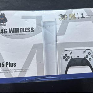 Puede incluir: Una caja de mando de juegos inalámbrico M15 Plus 2.4G en blanco y negro. La caja presenta el texto "2.4G WIRELESS" y "M15 Plus". El mando tiene un control de doble balancín y admite 10 juegos de formato simulador.