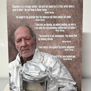 K&ouml;nnte beinhalten: Eine Sammelkarte mit einem Portr&auml;t von Werner Herzog und ihm zugeschriebenen Zitaten. Die Karte hat eine silberfarbene Metallic-Oberfl&auml;che und enth&auml;lt den Text "faux show COLLECTIBLES". Die Karte ist f&uuml;r Personen ab 13 Jahren geeignet.