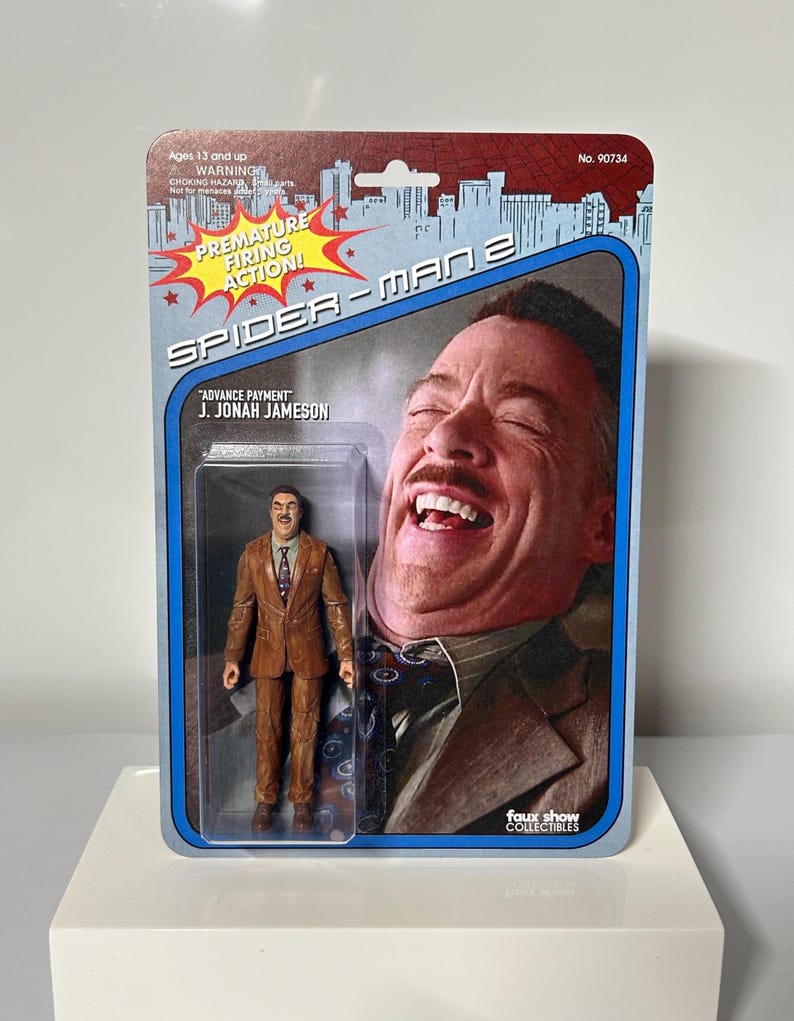Pu&ograve; includere: Action figure di Spider-Man 2 con J. Jonah Jameson in abito marrone, confezionata in un blister retr&ograve; blu e rosso. La confezione include il testo "PREMATURE FIRING ACTION!" e "ADVANCE PAYMENT".