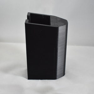 May include: A black 3D printed plastic stand with a rectangular base and a curved top.