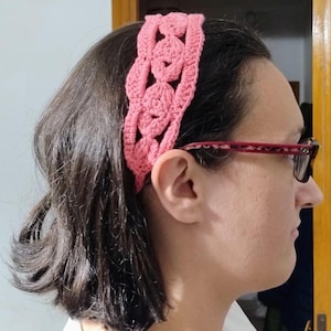 Peut inclure: Un bandeau rose en crochet avec un motif ajouré. Le bandeau est fait d'un fil doux et texturé et se porte sur le front. Le bandeau est un accessoire élégant.