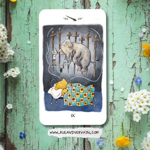 May include: A rectangular tarot card featuring a watercolor illustration of a yellow bear sleeping under a blue and yellow checkered quilt with red flowers. Above the bear, a thought bubble shows an elephant and two figures with swords.