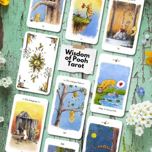 May include: A Wisdom of Pooh Tarot deck featuring multiple cards with watercolor illustrations of Winnie the Pooh characters in various scenes, including a card labeled The Magician and Page of Honey Pots, arranged around a central title card.