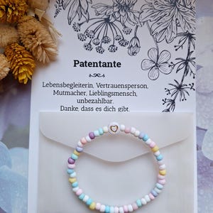 Ein pastellfarbenes Perlen-Armband mit einem goldenen Herz - Geschenk für die Patentante, Taufe - inkl. Karte bestellen Patentante