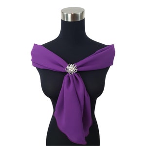 May include: A purple chiffon scarf with a silver and pearl brooch.