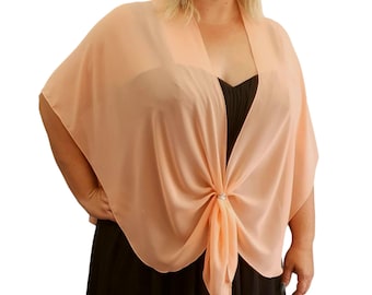 May include: A peach-coloured, sheer shawl with a knot detail at the centre. The shawl is draped over a black dress. A small, silver-coloured embellishment is at the knot. The shawl has a flowing, elegant design.