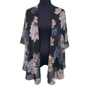 May include: Black floral kimono with a sheer, lightweight design. The kimono features large, colourful floral patterns in shades of pink, blue, and beige. The open-front style drapes elegantly, offering a versatile layering piece.