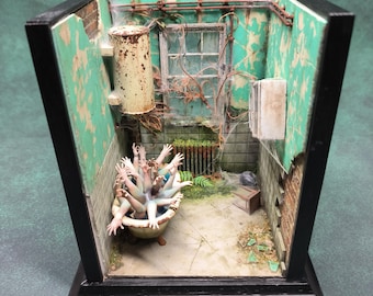 Op de afbeelding: Een miniatuur diorama van een vervallen badkamer. De focus ligt op een badkuip vol uitgestrekte handen. De muren zijn verweerd turquoise, met een roestige boiler en een met spinnenwebben bedekt raam. De scène is omlijst in een zwarte schaduwdoos.