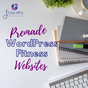 May include: A top-down view of a desk setup with a keyboard, notebooks, and a coffee cup. The image showcases the text "Premade WordPress Fitness Websites" in purple and blue, alongside the J'ADORN Web Solutions logo.