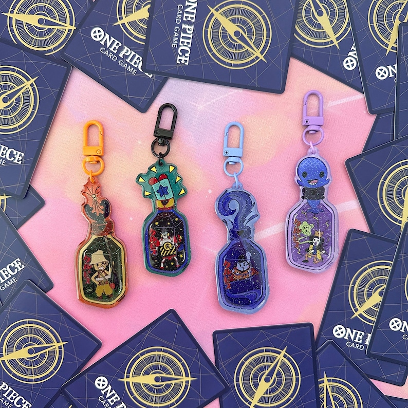 Pu&ograve; includere: Quattro portachiavi colorati con personaggi dell'anime One Piece. Ogni portachiavi &egrave; una bottiglia con un personaggio diverso al suo interno. Le bottiglie sono in acrilico trasparente e hanno un effetto glitter. I portachiavi sono attaccati ad anelli di metallo argentati.