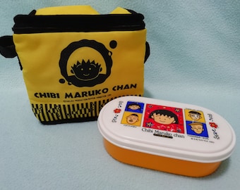 May include: A yellow lunch bag with a black strap and the text "Chibi Maruko Chan" printed on it. The bag is next to a yellow and white lunchbox with a cartoon character on the lid. The lunchbox has the text "Chibi Maruko chan" printed on it.