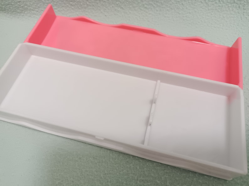 May include: A white plastic storage box with a pink lid. The box has a divider inside to separate items.