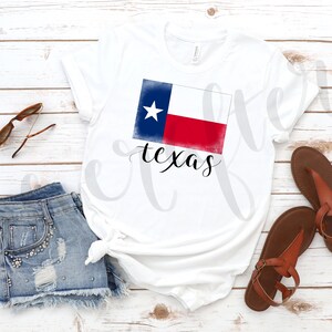 May include: White t-shirt featuring a distressed watercolour design of the Texas flag and the word "texas" in cursive script.