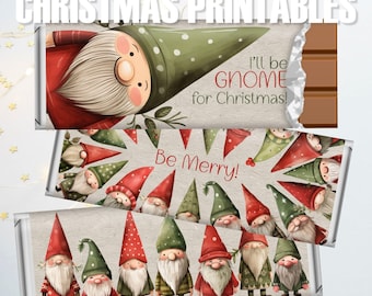 Puede incluir: Envoltorios de barras de chocolate con diseños navideños. Los envoltorios presentan ilustraciones de gnomos con sombreros rojos y verdes, con texto que dice "I'll be Gnome for Christmas!" y "Be Merry!"
