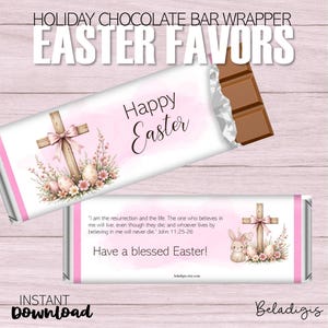 Pode incluir: Embrulho de barra de chocolate de Páscoa imprimível com fundo rosa e uma cruz com um laço rosa. O embrulho apresenta o texto "Feliz Páscoa" e um versículo bíblico de João 11:25-26. O texto "Feliz Páscoa!" também está incluído.