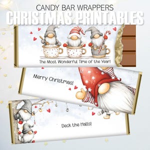 Puede incluir: Envoltorios de barras de chocolate con diseños navideños. Los envoltorios presentan ilustraciones de gnomos, corazones y texto festivo. Un envoltorio dice "The Most Wonderful Time of the Year!", otro dice "Merry Christmas!" y el último dice "Deck the Halls!"