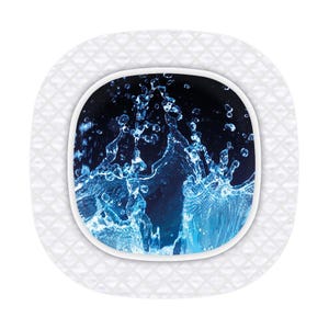 Könnte beinhalten: Ein weißer Keramikteller mit einem erhabenen, strukturierten Design. Die Mitte des Tellers hat einen kreisförmigen Ausschnitt mit einem blauen und schwarzen Bild von spritzendem Wasser.