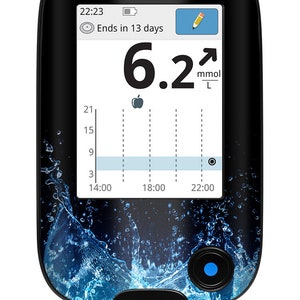 Op de afbeelding: Een zwart-blauwe bloedglucosemeter met een digitaal display dat een waarde van 6,2 mmol/L laat zien. Het display toont ook de tijd 22:23 en het bericht "Eindigt in 13 dagen".