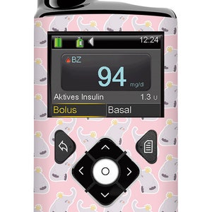 Könnte beinhalten: Eine rosa und graue Insulinpumpe mit einem Cartoon-Elefantenmuster. Der Bildschirm zeigt "BZ", "94 mg/dl", "Aktives Insulin 1.3 u", "Bolus" und "Basal". Die Uhrzeit ist 12:24.