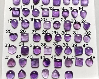 Könnte beinhalten: Eine Sammlung von 54 Amethyst-Edelsteinen, angeordnet in Reihen und von 1 bis 54 nummeriert. Die Edelsteine sind in verschiedenen Formen und Größen, mit einem violetten Farbton.