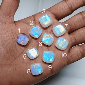 Peut inclure: Dix cabochons de pierre de lune iris&eacute;s de diff&eacute;rentes tailles et formes, num&eacute;rot&eacute;s de 1 &agrave; 10, sont pr&eacute;sent&eacute;s sur une main.