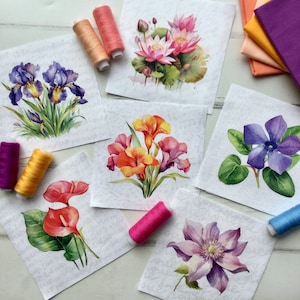 Puede incluir: Seis patrones de bordado floral diferentes en cuadrados de tela blanca. Los patrones incluyen un nenúfar rosa, un iris morado, una vincapervinca azul, una flor rosa y blanca, una flor naranja y un lirio rojo.
