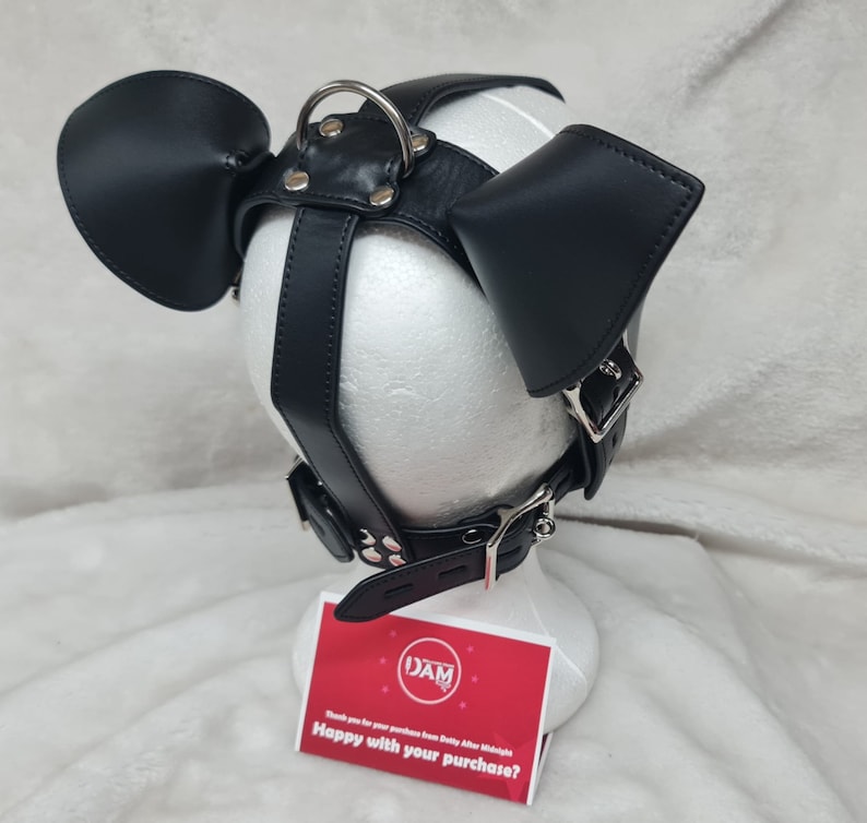 May include: Black leather dog mask with silver hardware and two floppy ears. The mask is on a white mannequin head. The text on the card reads "DAM Thank you for your purchase from Dotty After Midnight Happy with your purchase?"