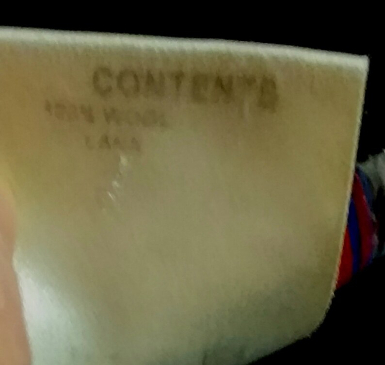 May include: A white tag with the word "CONTENT" printed in black. The tag also has the text "150N WIDE" and "L444" printed in black.
