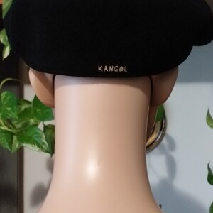 May include: Black wool Kangol beret with a gold logo on the back.