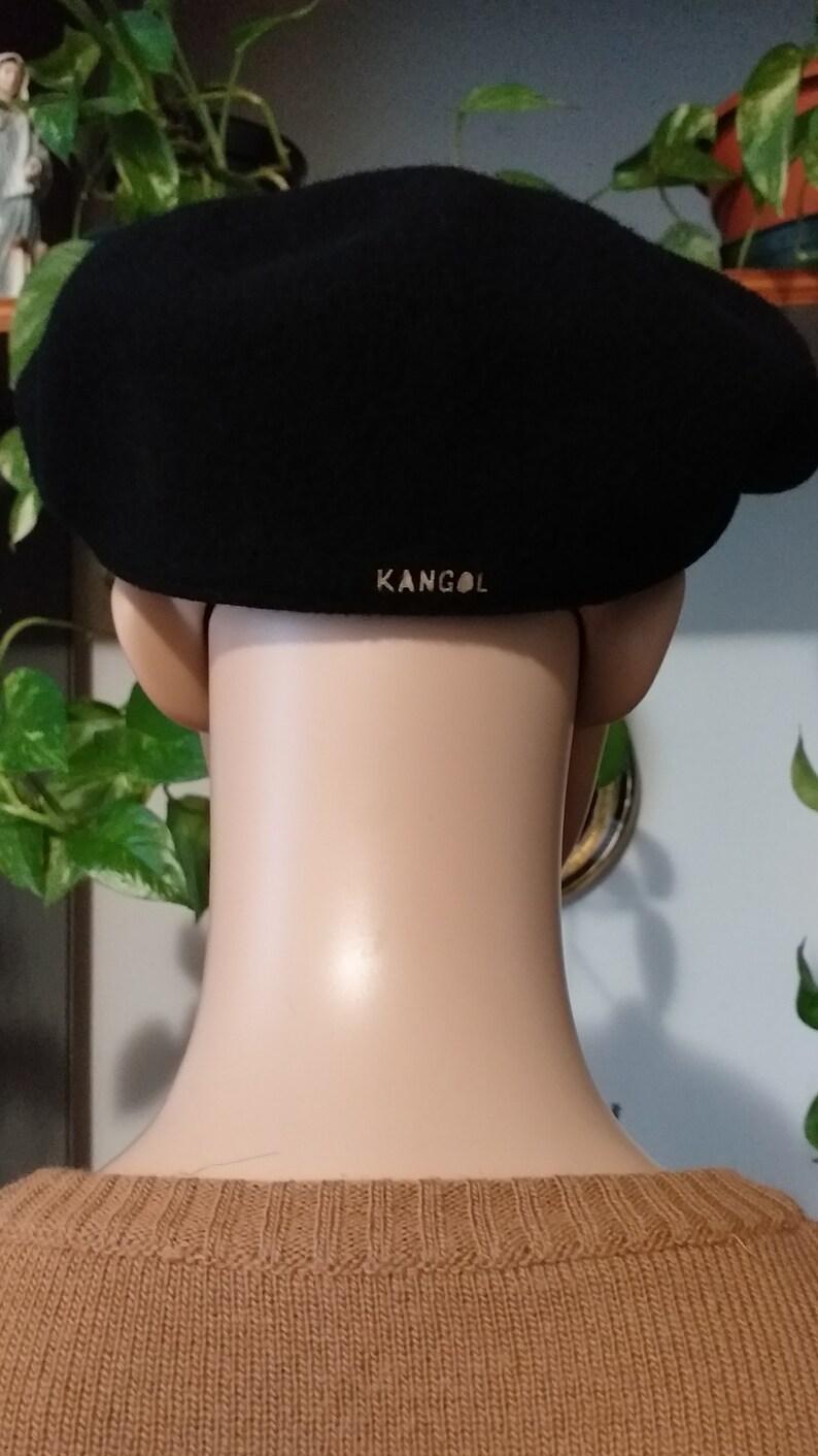 May include: Black wool Kangol beret with a gold logo on the back.