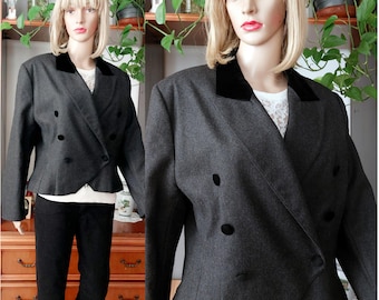 May include: A grey double-breasted blazer with a black velvet collar and black buttons. The jacket is displayed on a mannequin, paired with black trousers and a white top. The blazer has a tailored fit.