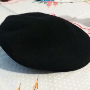May include: A black wool flat cap.
