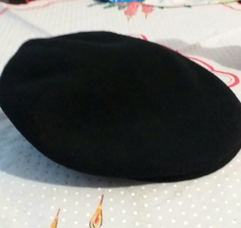 May include: A black wool flat cap.