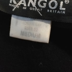 May include: Black Kangol hat with a white label that says "Made in Great Britain" and a white tag that says "Size 57.5 Medium".